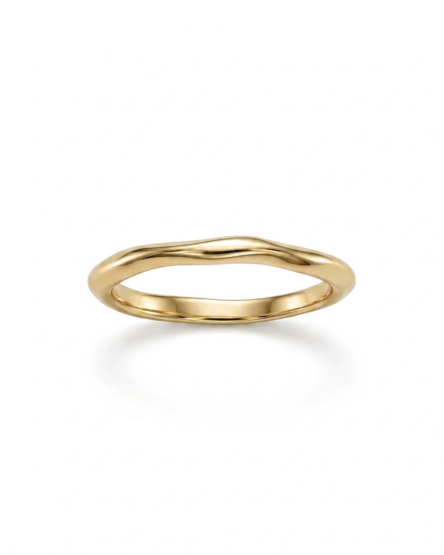 Dainty gold wedding ring with a smooth, uneven organic wave design on a white background.