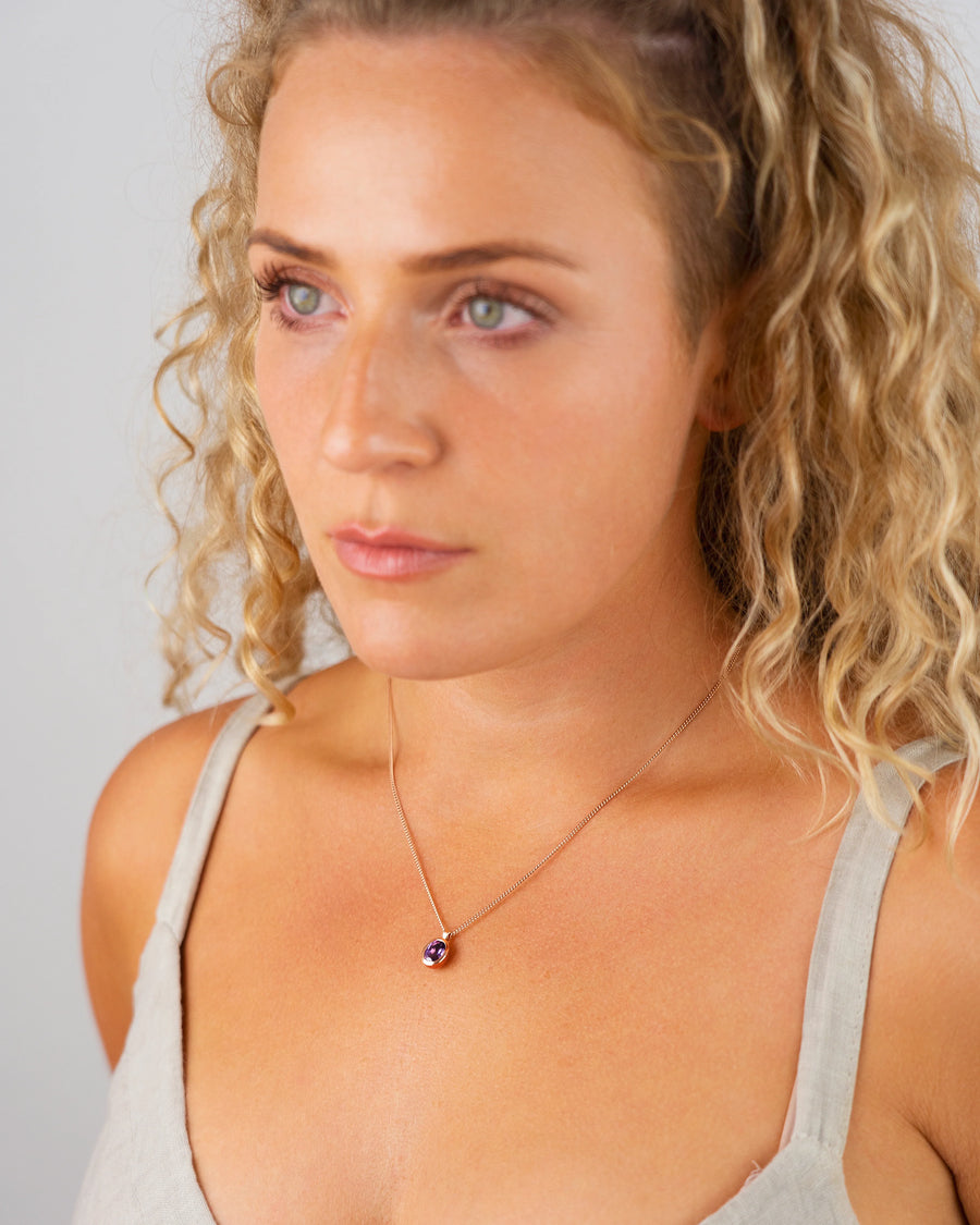 Woman wearing a handmade luxury amethyst pendant necklace with organic design