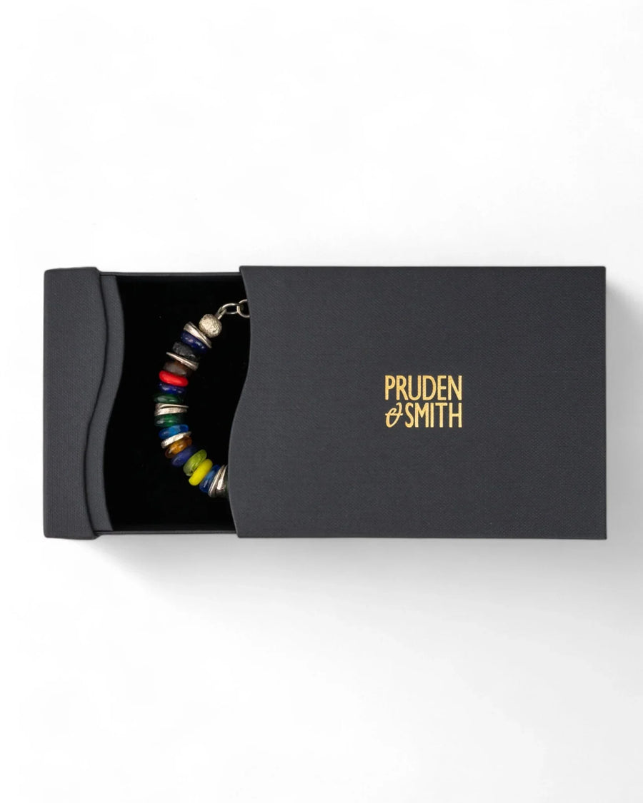Colorful recycled glass bead bracelet in a black gift box on a white background