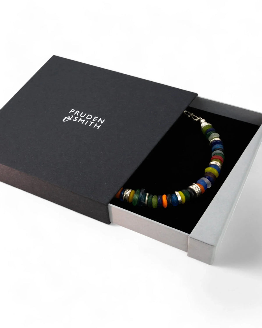 Colorful recycled glass bead necklace with silver accents in a gift box on white background