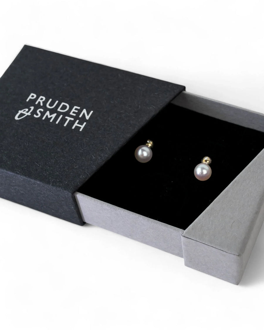Akoya pearl and diamond stud earrings in a luxury gift box on white background