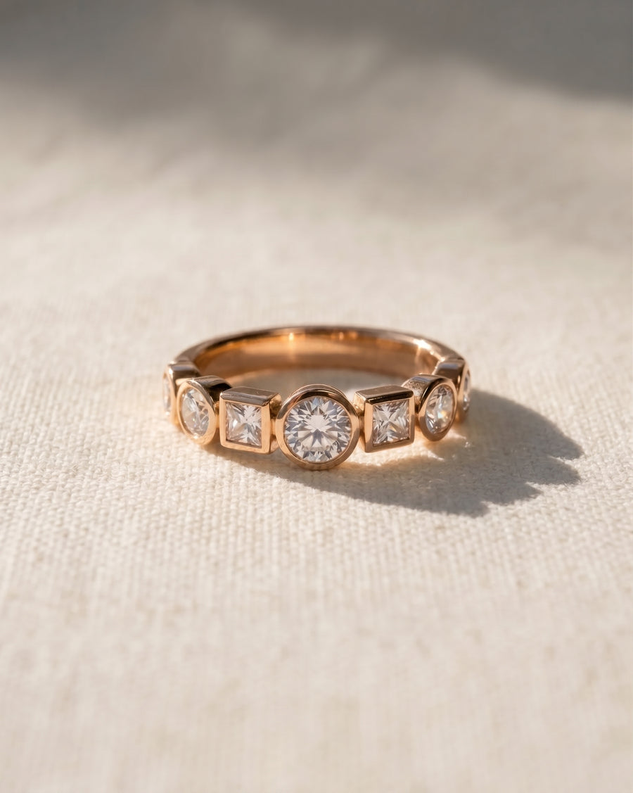 18ct rose gold half eternity ring with alternating round and square diamonds.