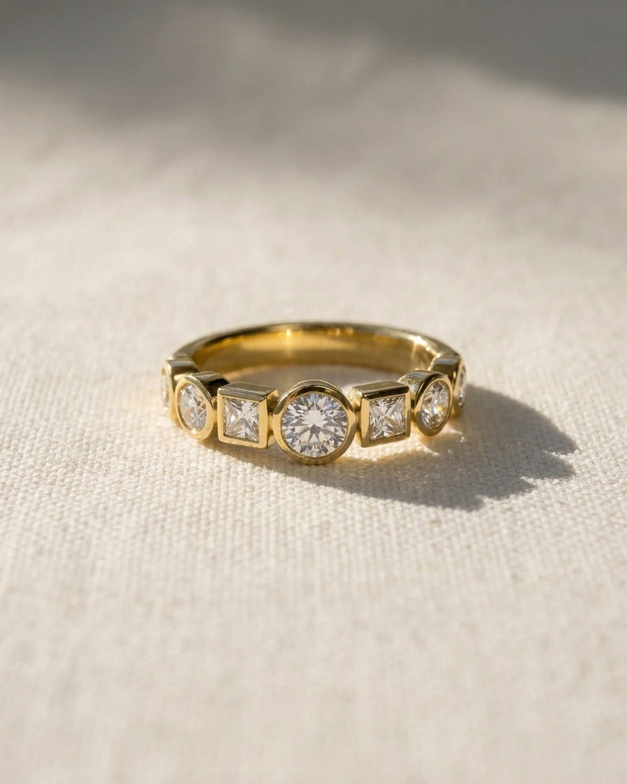 18ct yellow gold half eternity ring with alternating round and square diamonds.