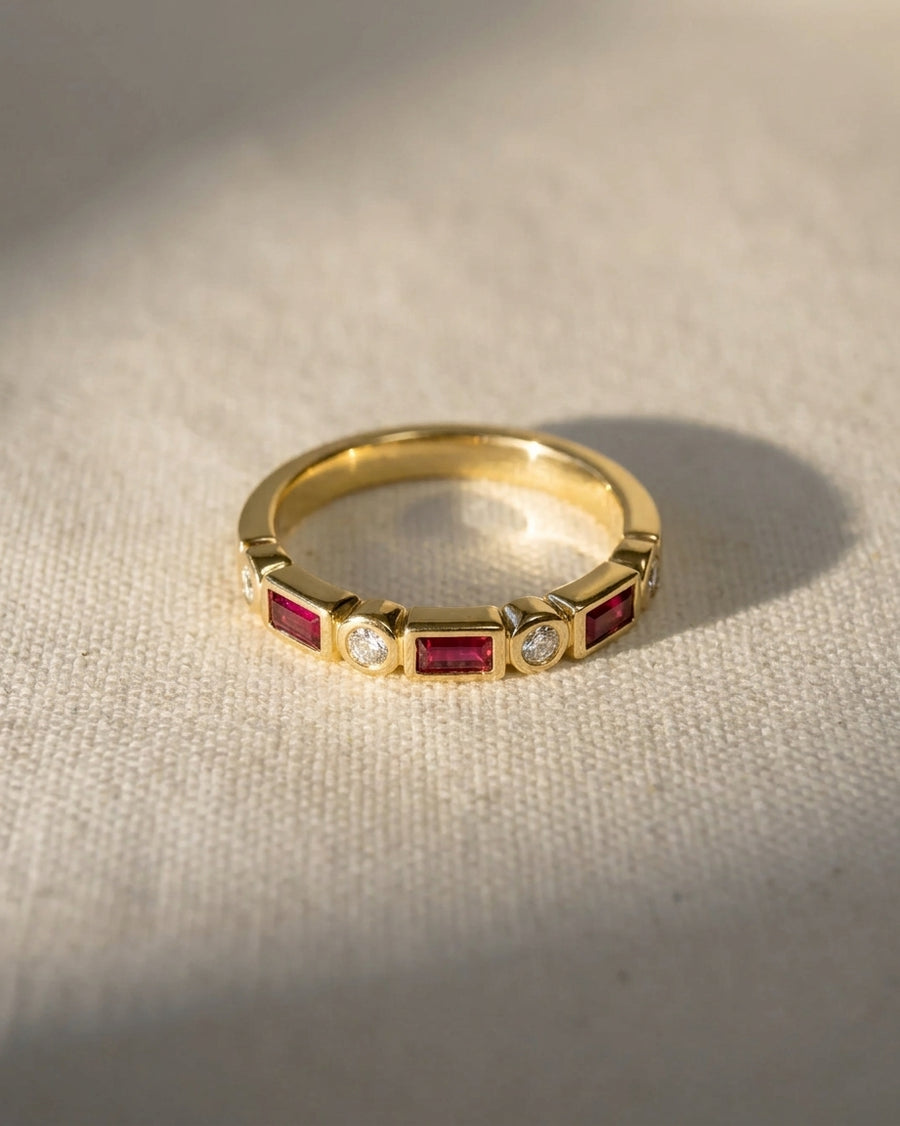 Yellow gold eternity ring with alternating baguette rubies and round diamonds.