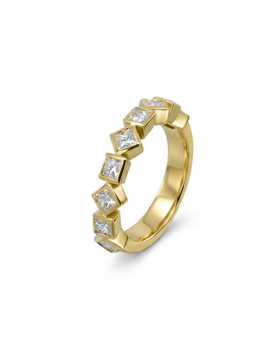 Gold half eternity ring with alternating princess cut diamonds.