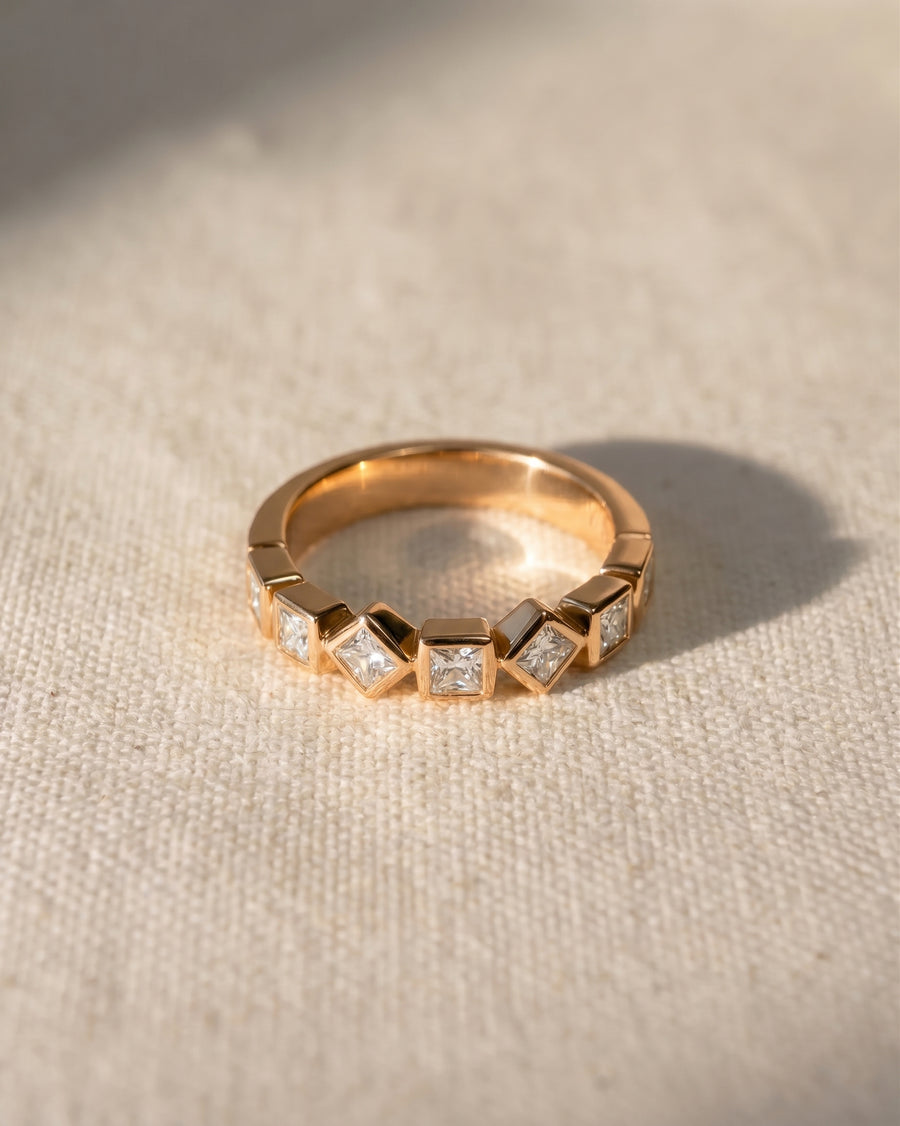 18ct rose gold half eternity ring with alternating princess cut diamonds.