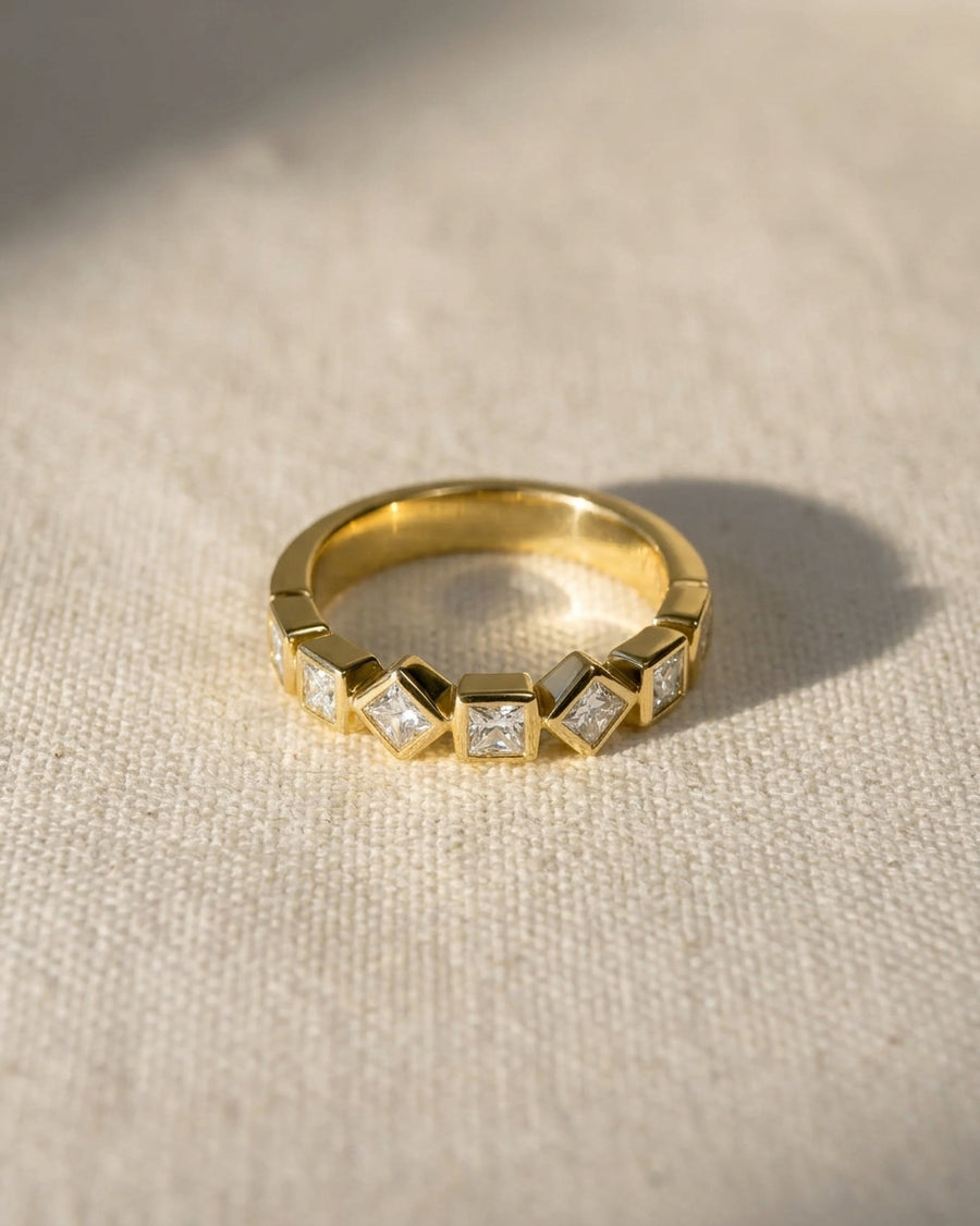 18ct yellow gold half eternity ring with alternating princess cut diamonds.
