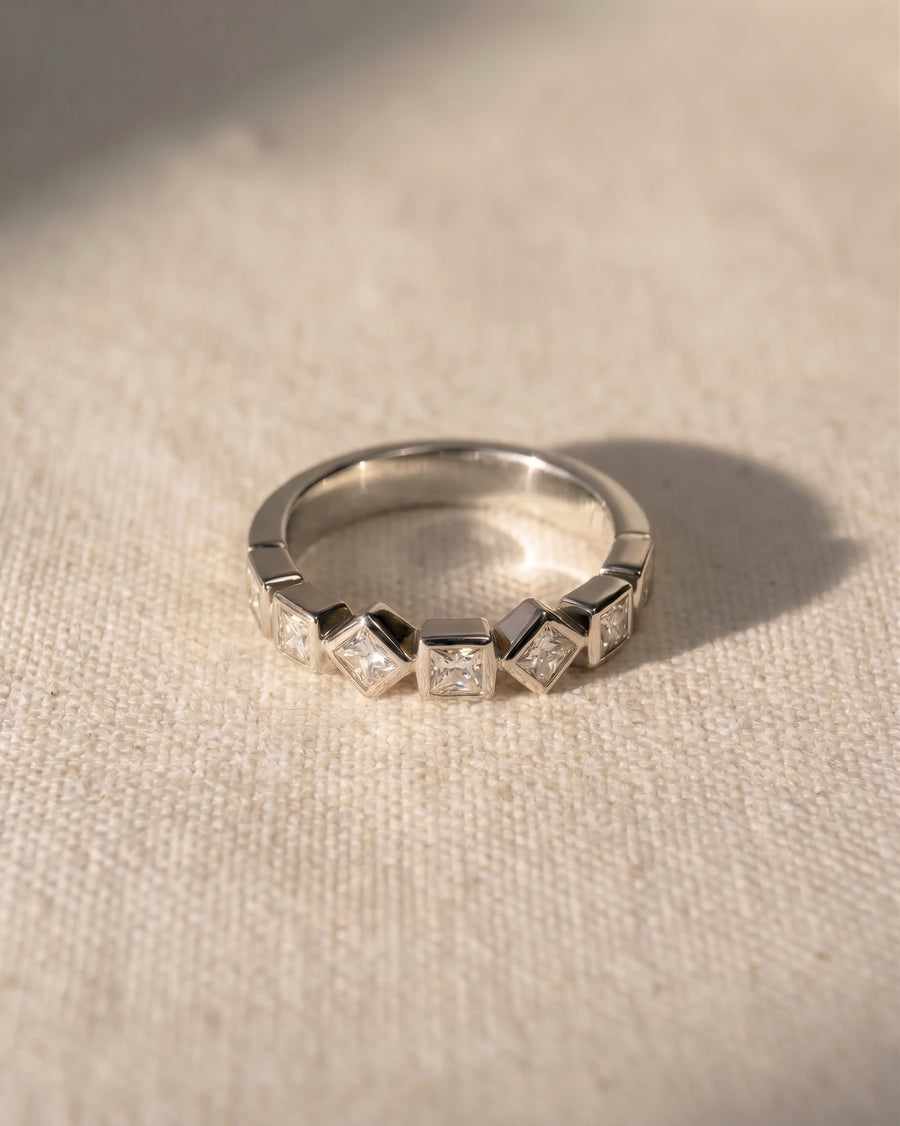 Platinum half eternity ring with alternating princess cut diamonds.