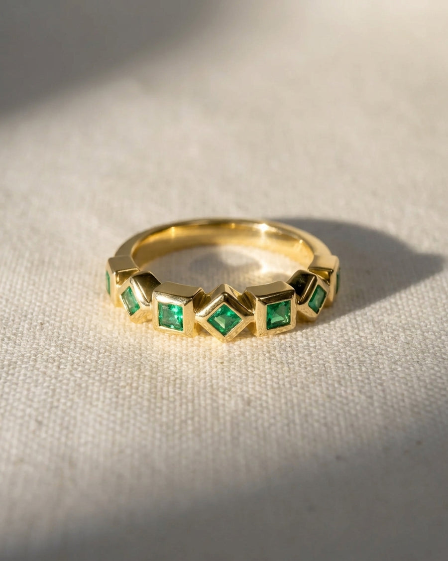 18ct yellow gold eternity ring with alternating square emeralds.