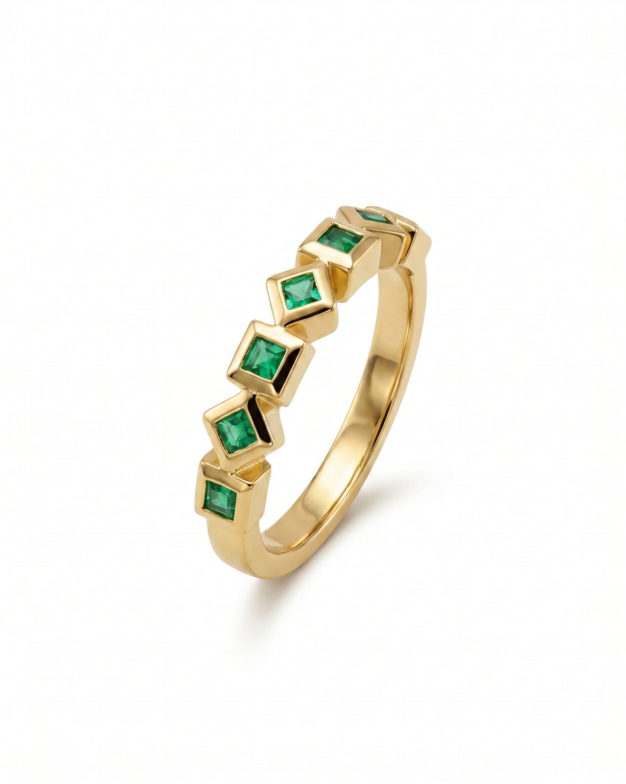 Gold eternity ring with alternating square emeralds.