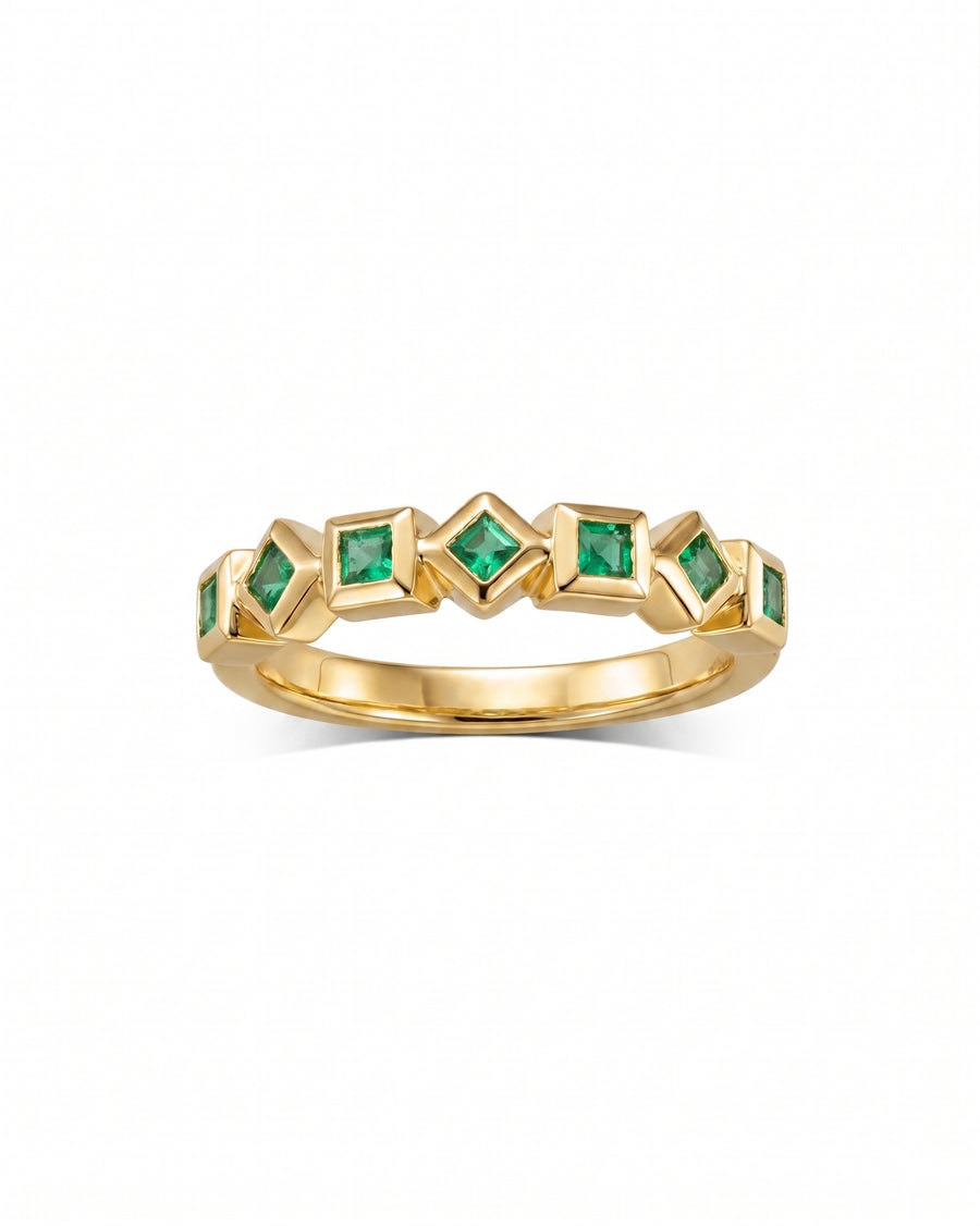 Gold eternity ring with alternating square and diamond-shaped emeralds.