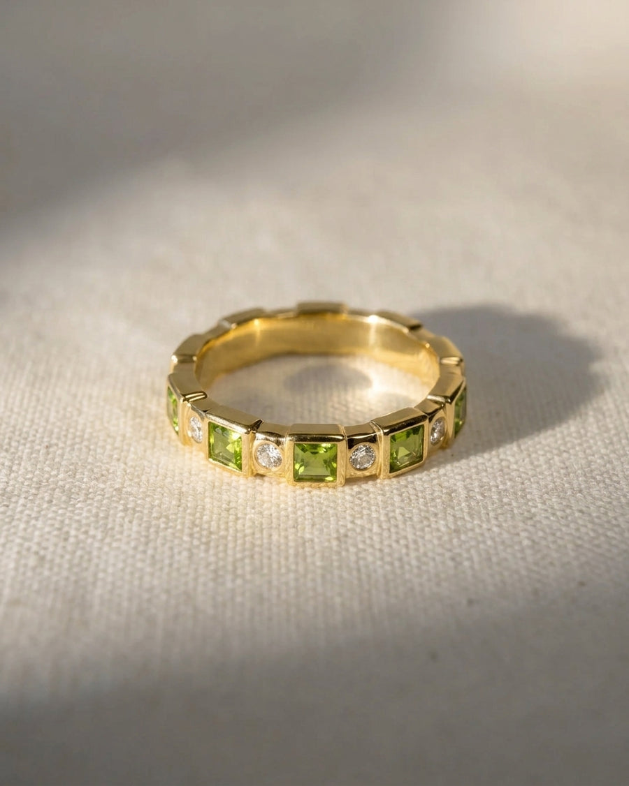 18ct yellow gold full eternity ring with alternating peridot and diamond gemstones.