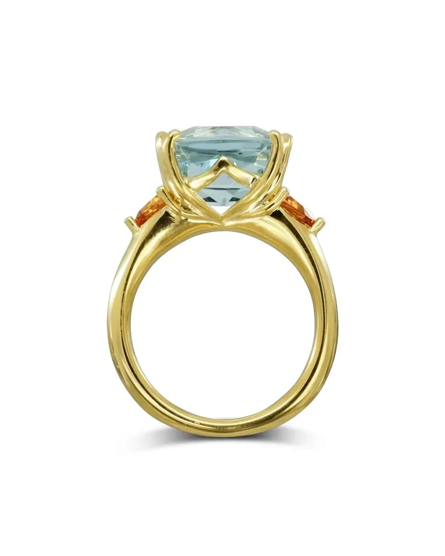 Gold dress ring with a large aquamarine and two orange sapphires.