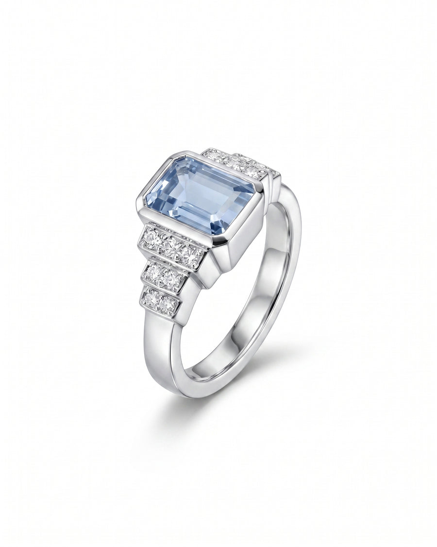 White gold Art Deco inspired engagement ring with an emerald-cut aquamarine and diamond accents.