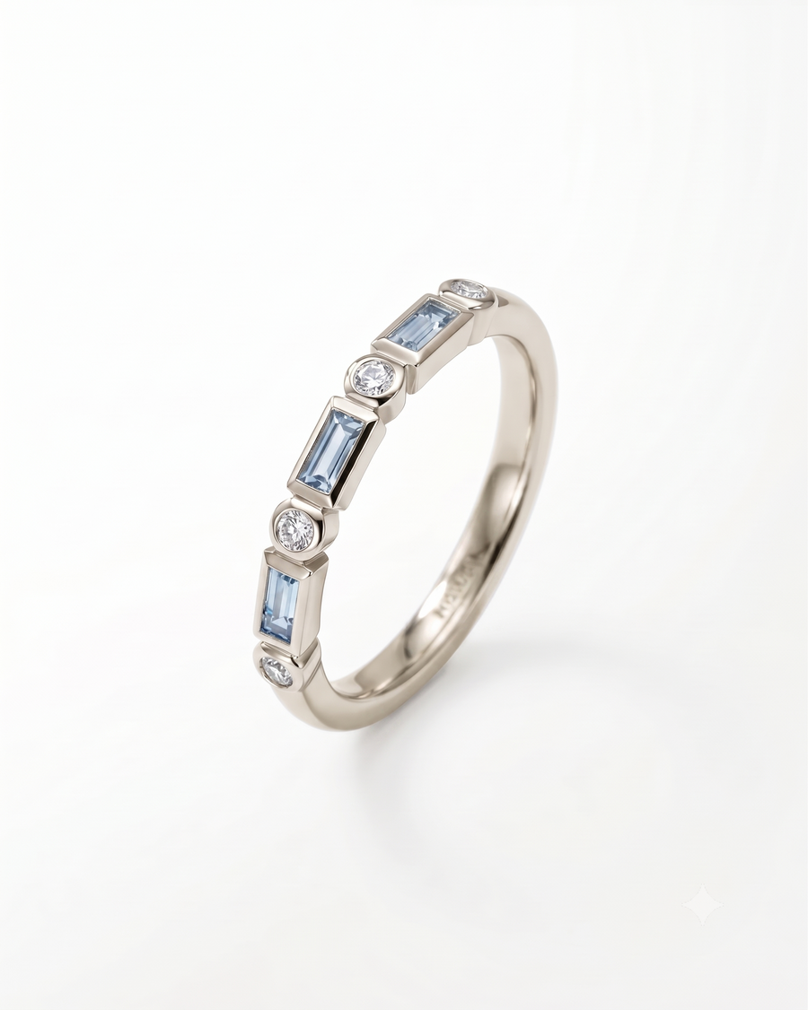 9ct white gold half eternity ring featuring alternating baguette aquamarines and round diamonds in a bezel setting.