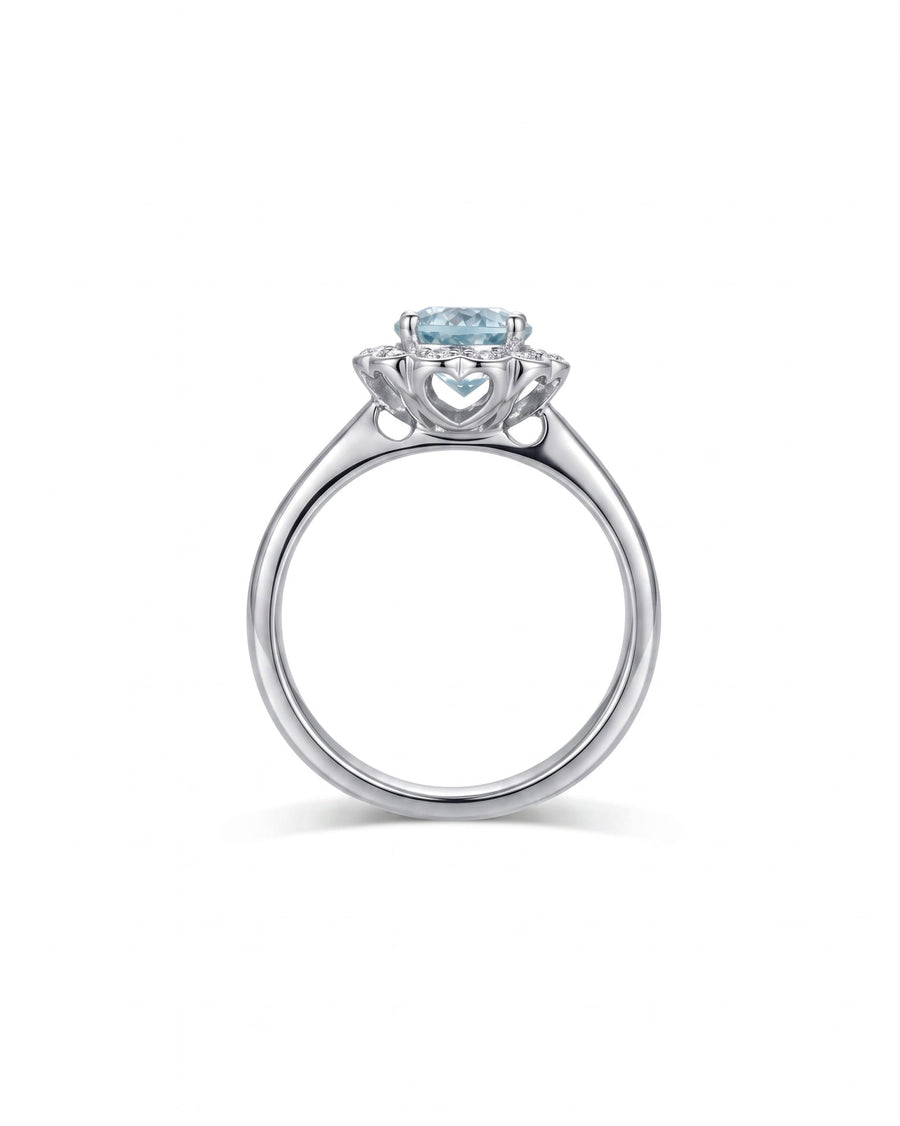 Silver engagement ring with a light blue aquamarine and scalloped diamond cluster.