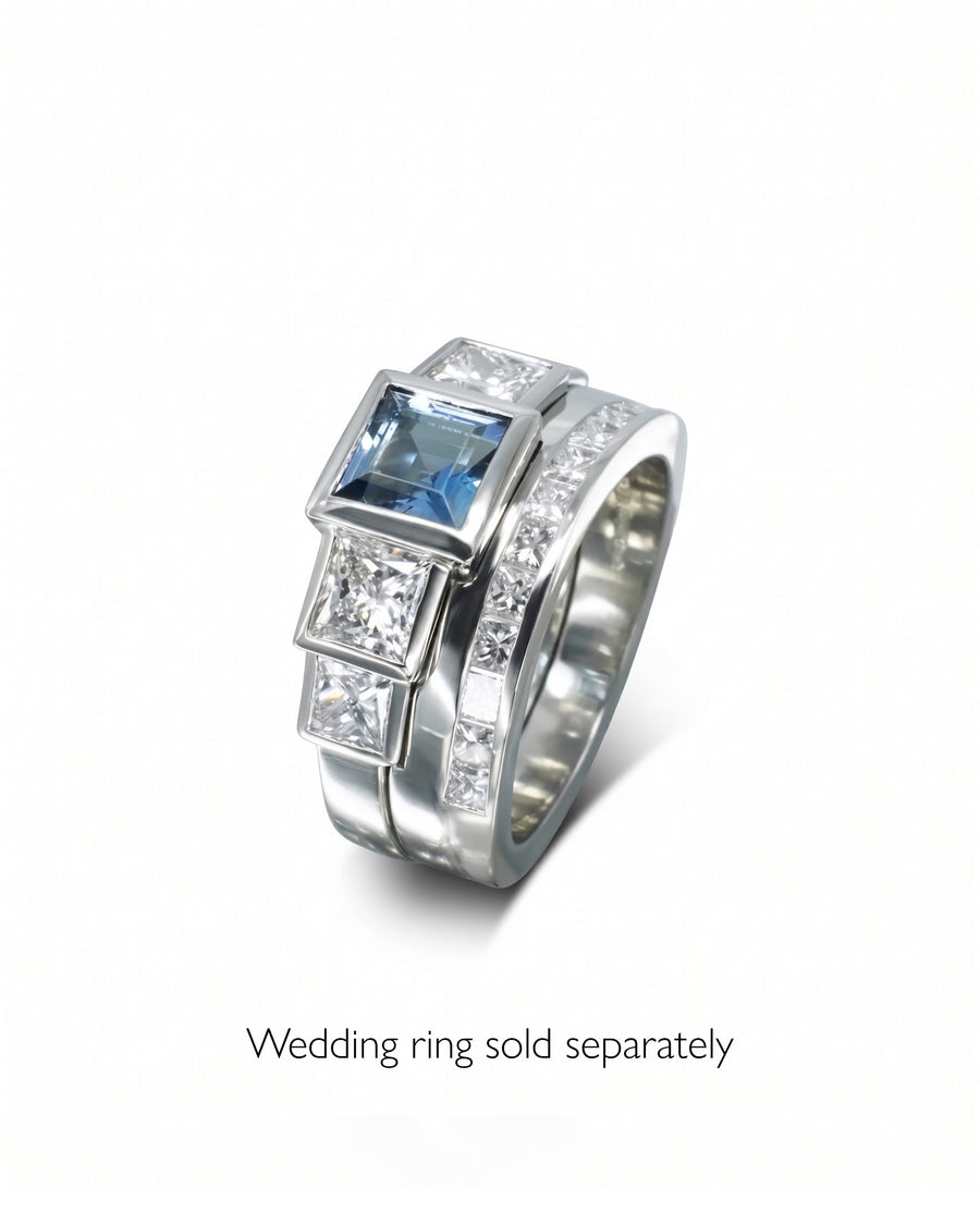 Platinum ring with a square aquamarine and two square diamonds, alongside a diamond band.
