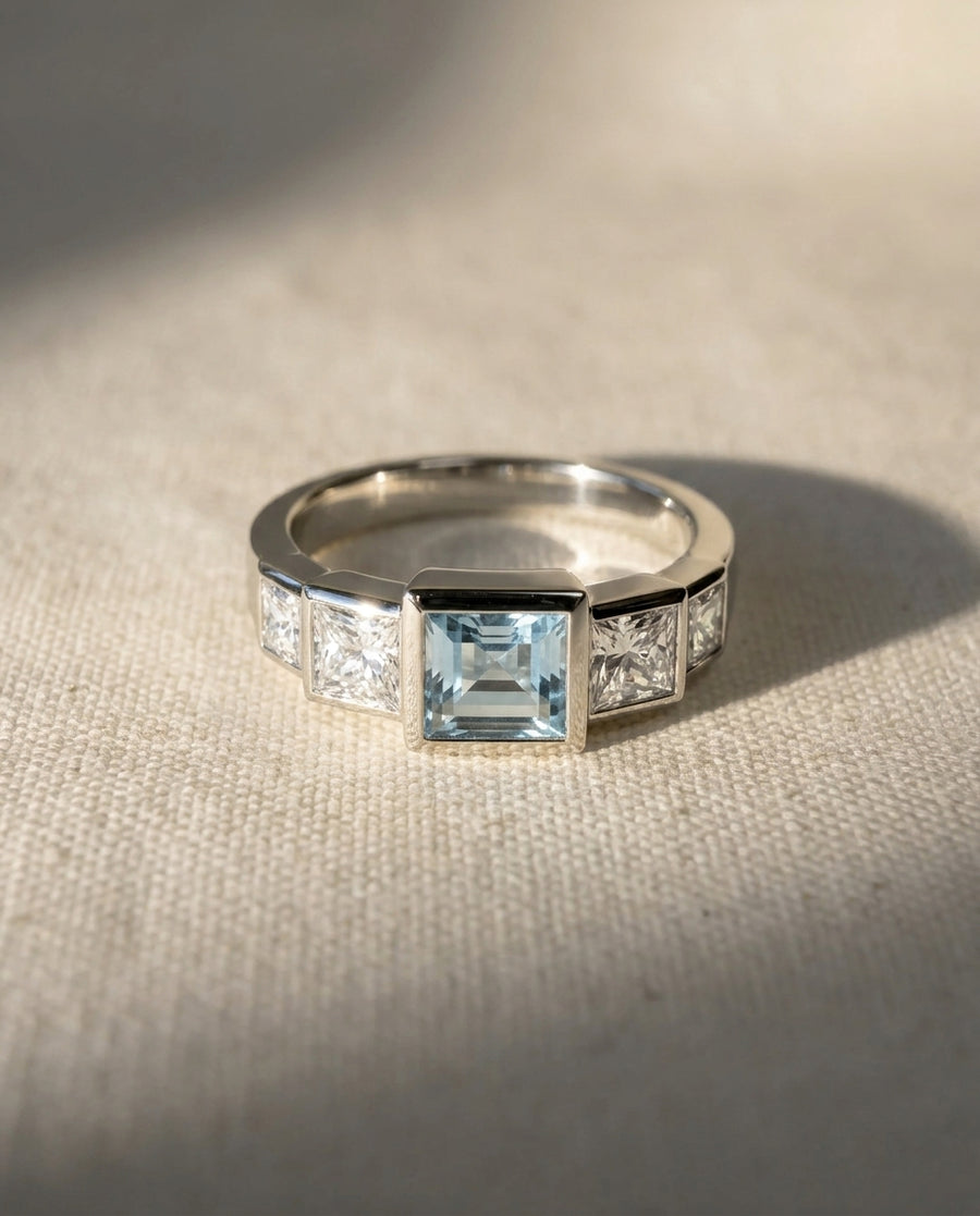 Platinum ring with a square aquamarine and baguette diamonds.