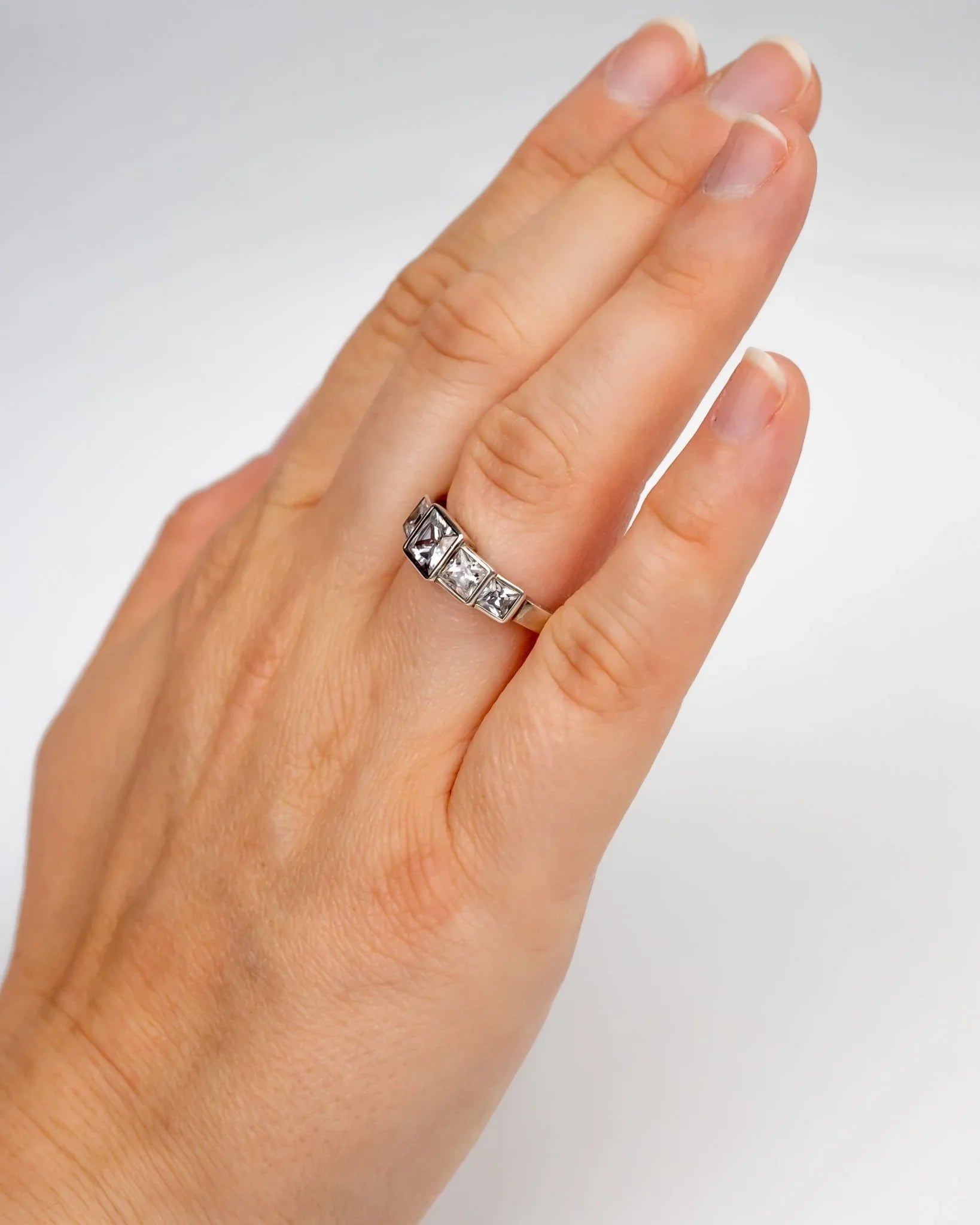 Art Deco platinum ring with square diamonds worn on a hand, elegant vintage jewellery