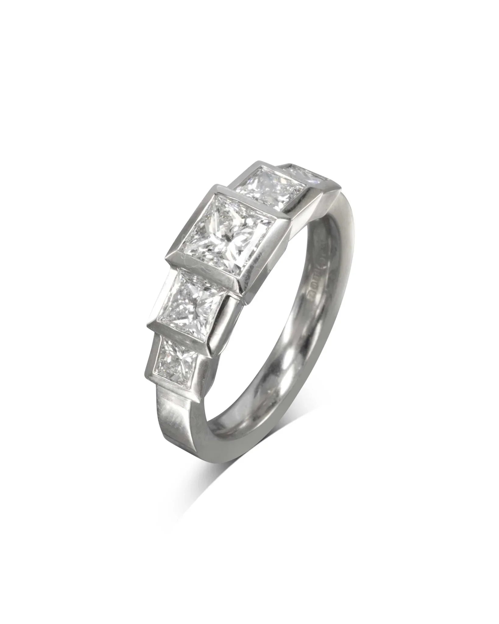 Art Deco platinum ring with four square-cut diamonds in geometric setting on white background