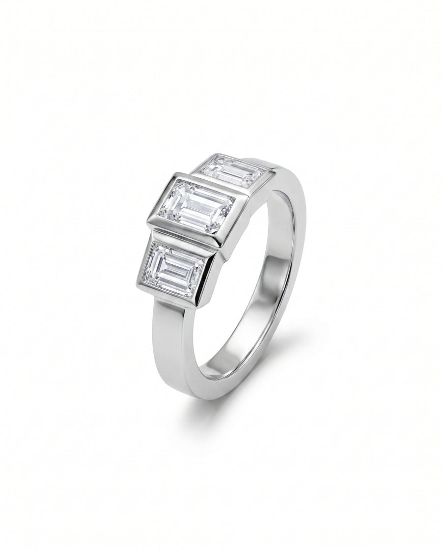 White gold ring with three emerald cut diamonds.