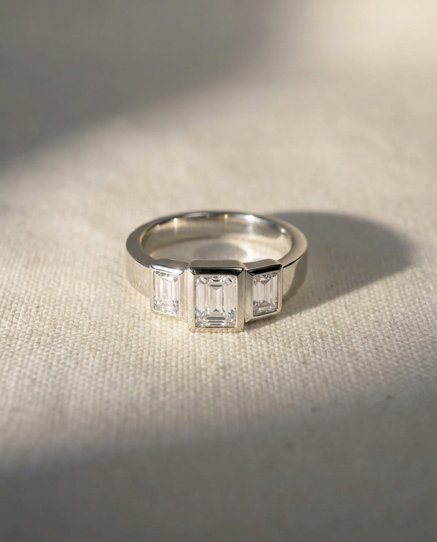Platinum ring with three emerald cut diamonds.