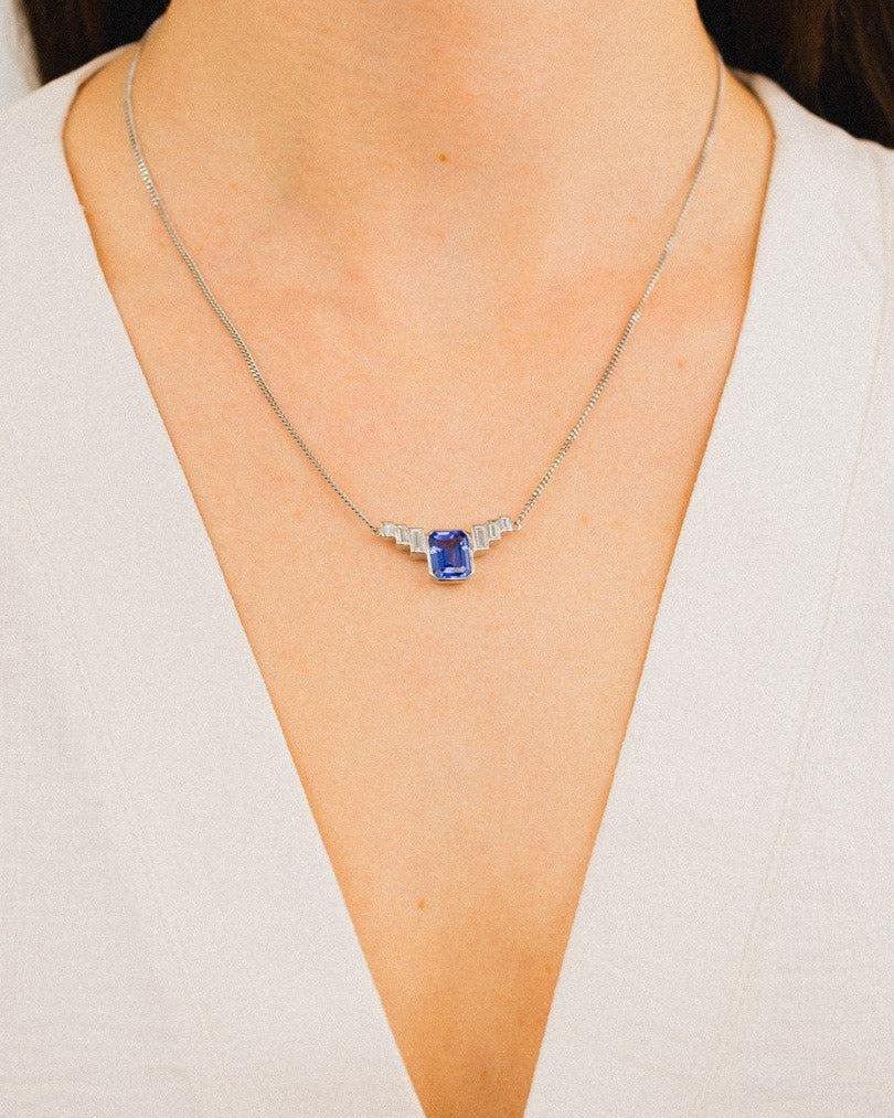 Art deco platinum aquamarine pendant necklace worn with deep v-neck dress