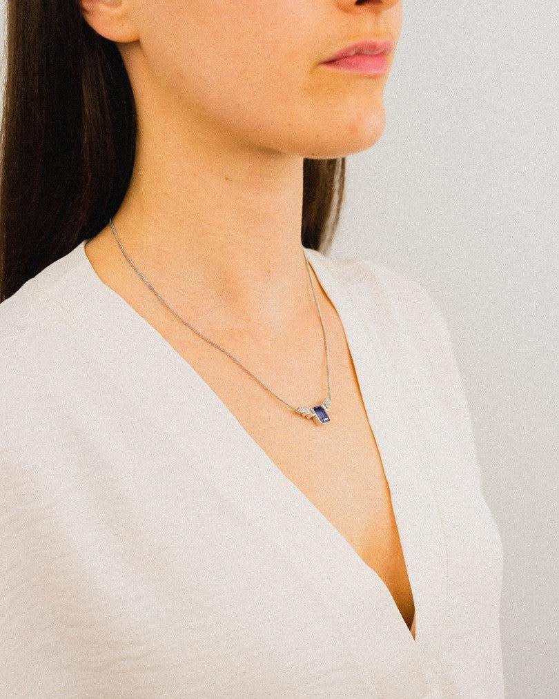 Woman wearing an art deco platinum aquamarine pendant necklace on a fine chain