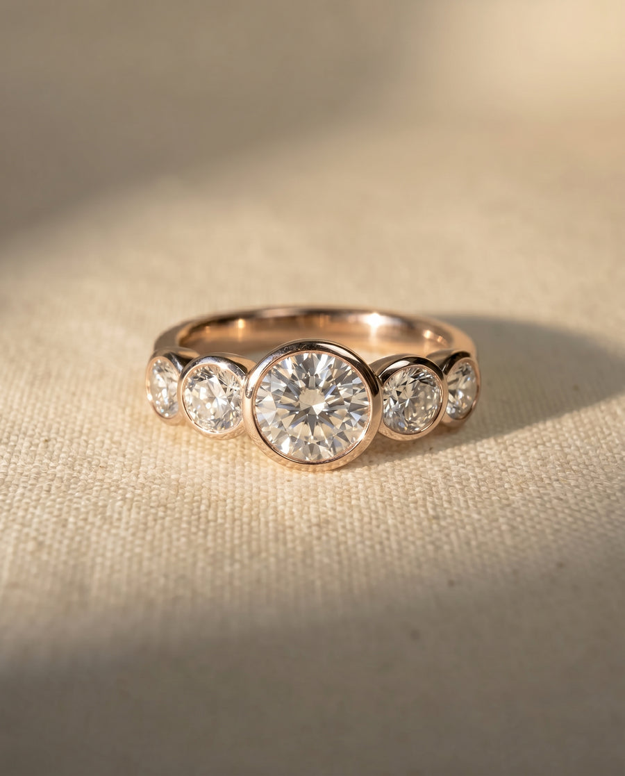 18ct rose gold engagement ring with five round brilliant cut diamonds.