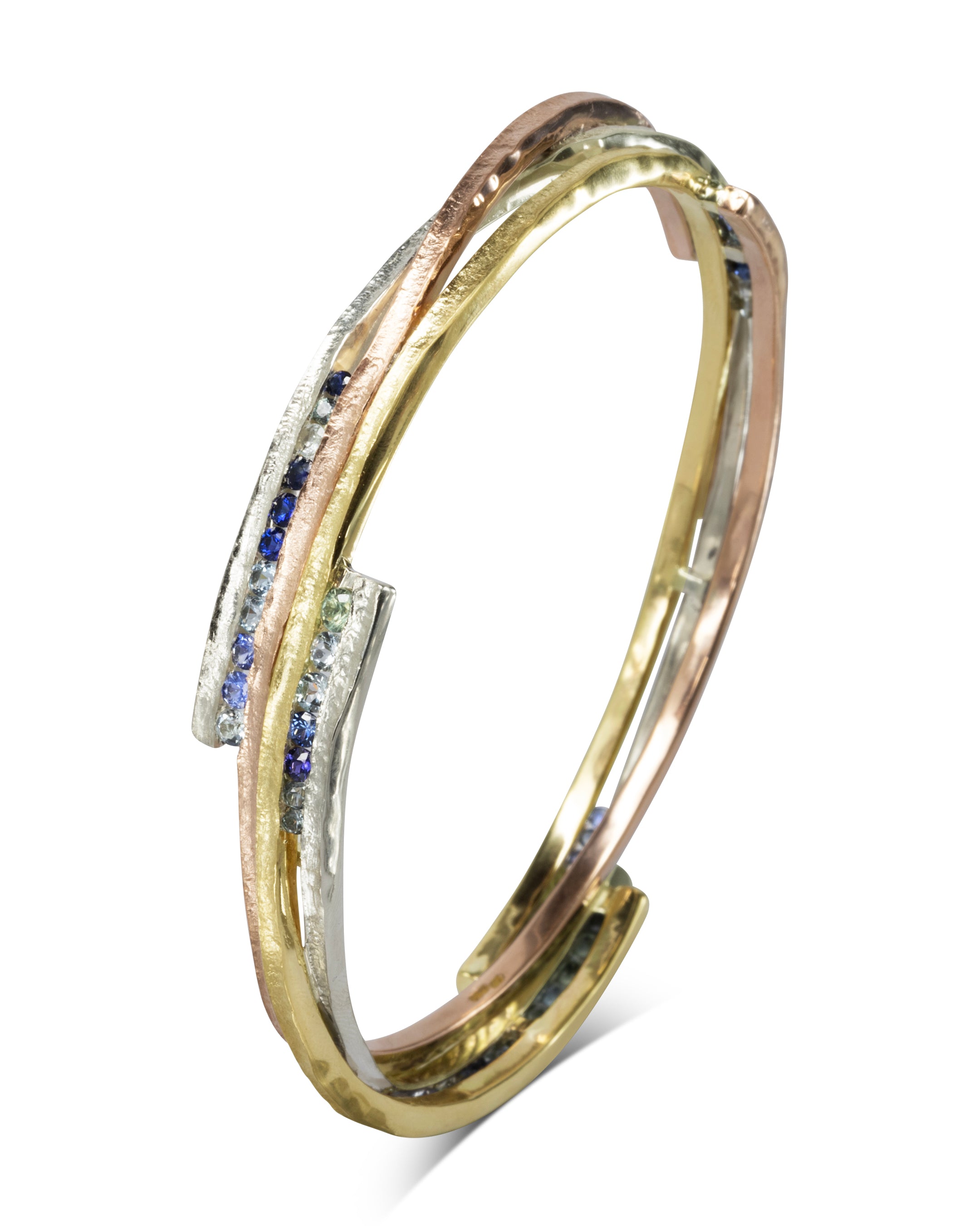 Mixed metal bangle with asymmetric sapphire and textured gold, rose gold, and silver bands.