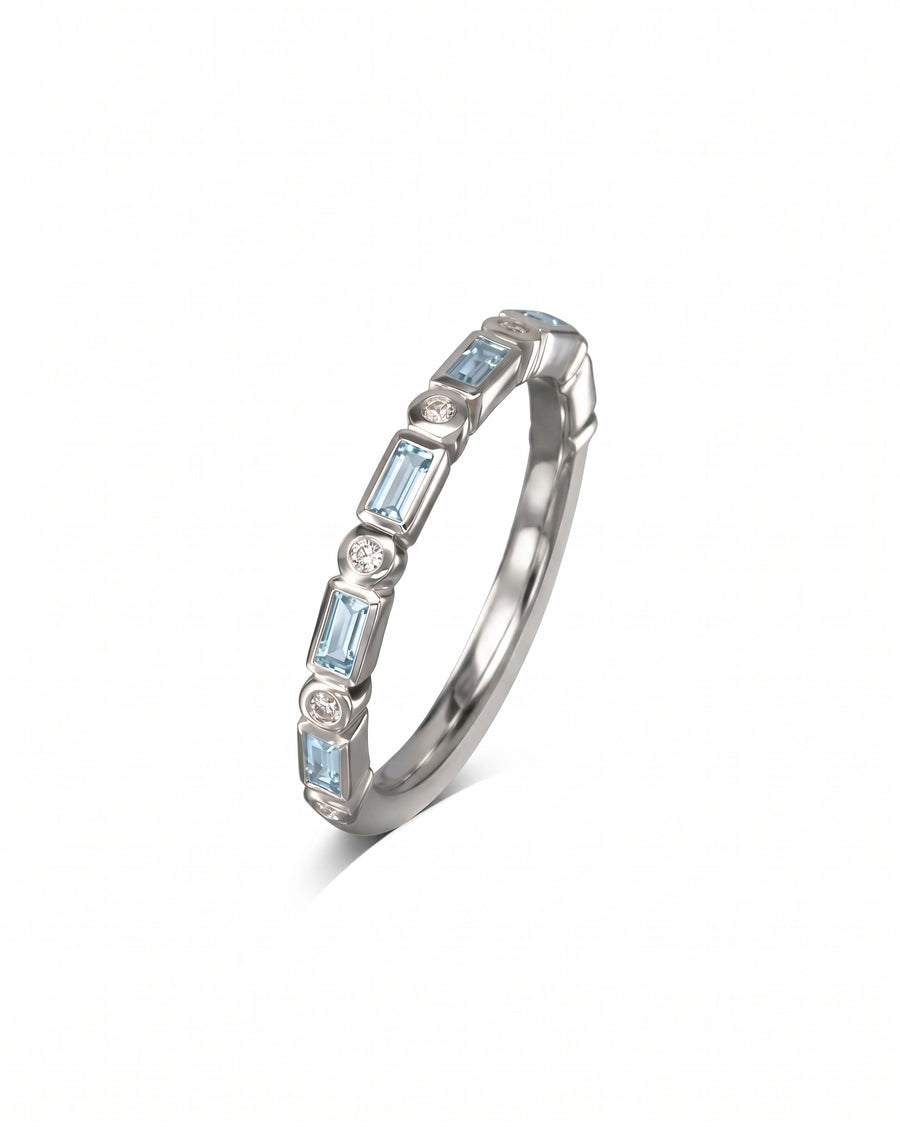 Silver eternity ring with baguette cut blue gemstones and round diamonds.