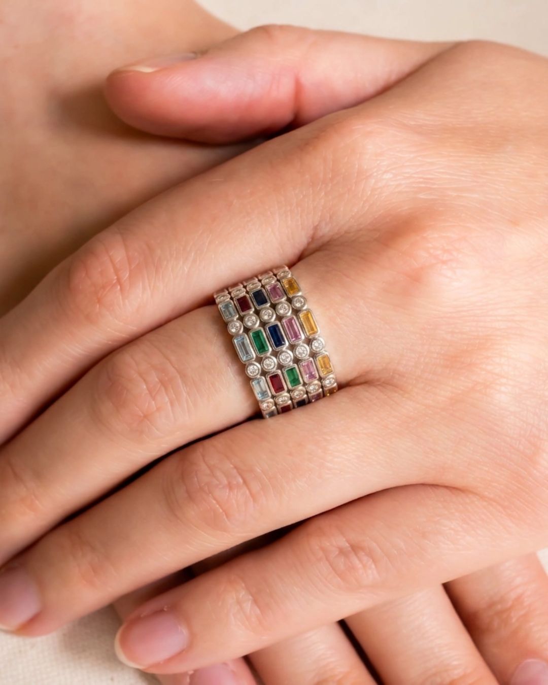 Silver eternity ring with baguette cut multicolored gemstones and diamonds.