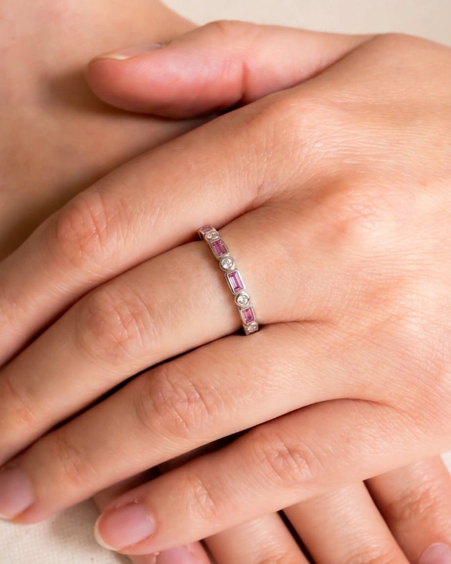 Silver eternity ring with baguette and round pink gemstones.