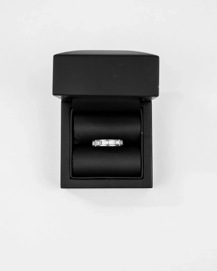 Platinum ring with baguette diamonds in a black box.