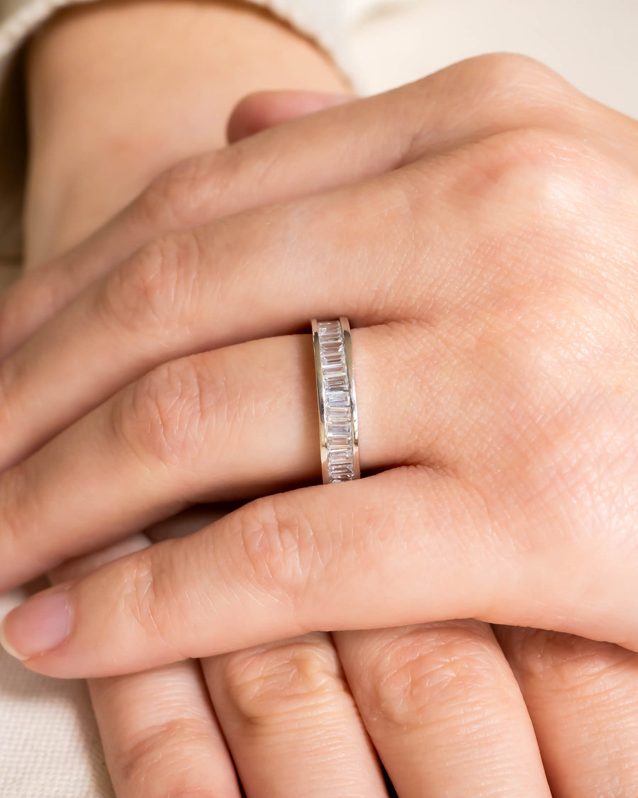 Platinum ring with baguette diamonds on a hand.
