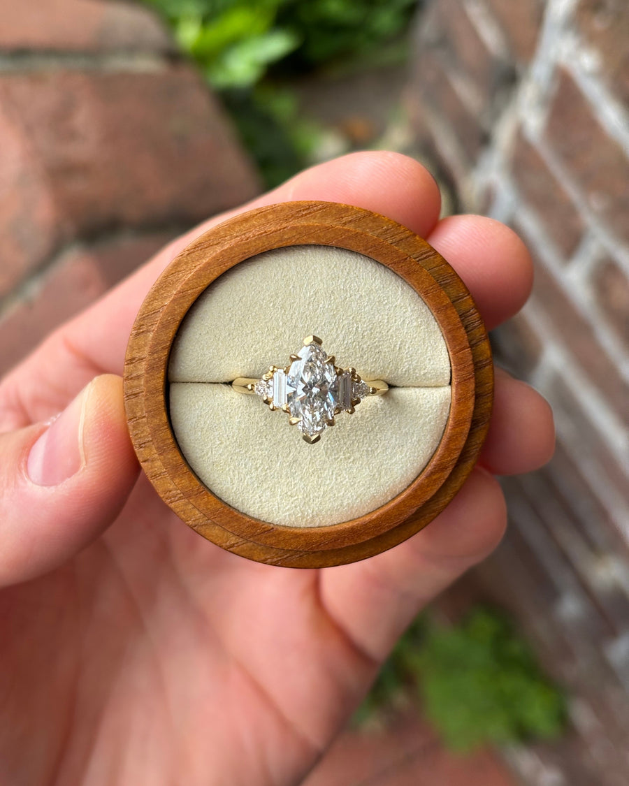 18ct yellow gold engagement ring featuring a 1.89ct marquise cut diamond with baguette side stones in a wooden box.