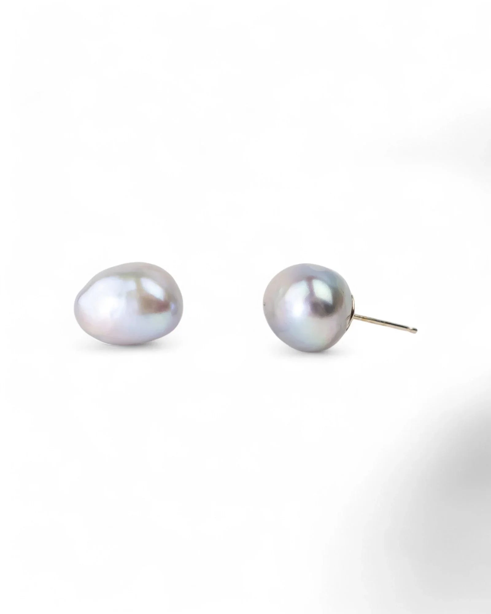 Two grey baroque pearl stud earrings with gold posts.
