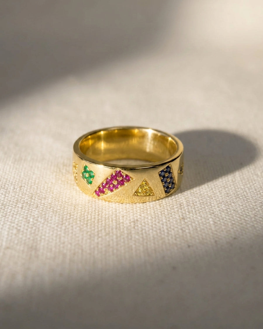 Gold eternity ring with colorful geometric gemstones.