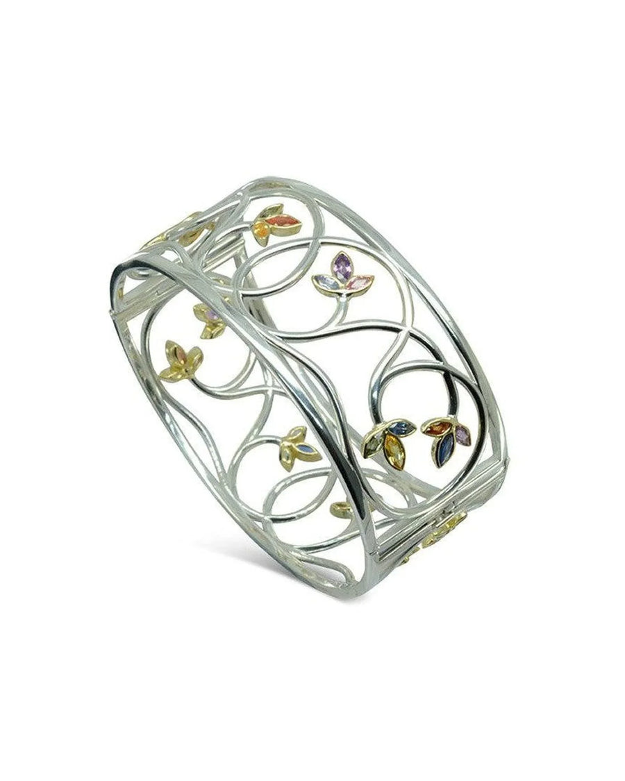 Handcrafted gold bangle with sapphire gemstones and organic floral motifs