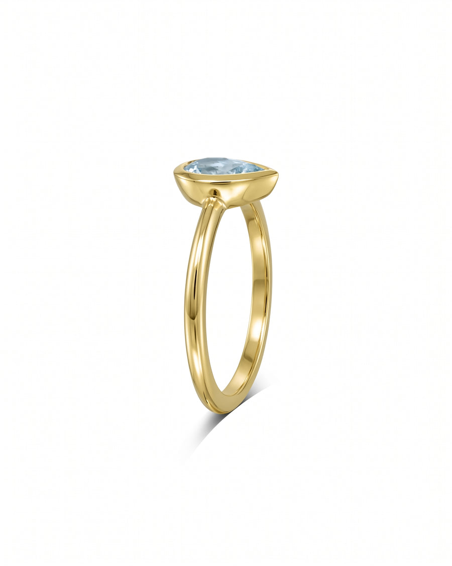 Gold ring with a bezel-set pear aquamarine solitaire.