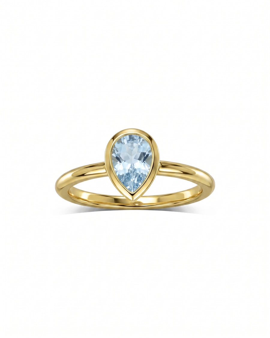Gold ring with a bezel-set pear aquamarine solitaire.