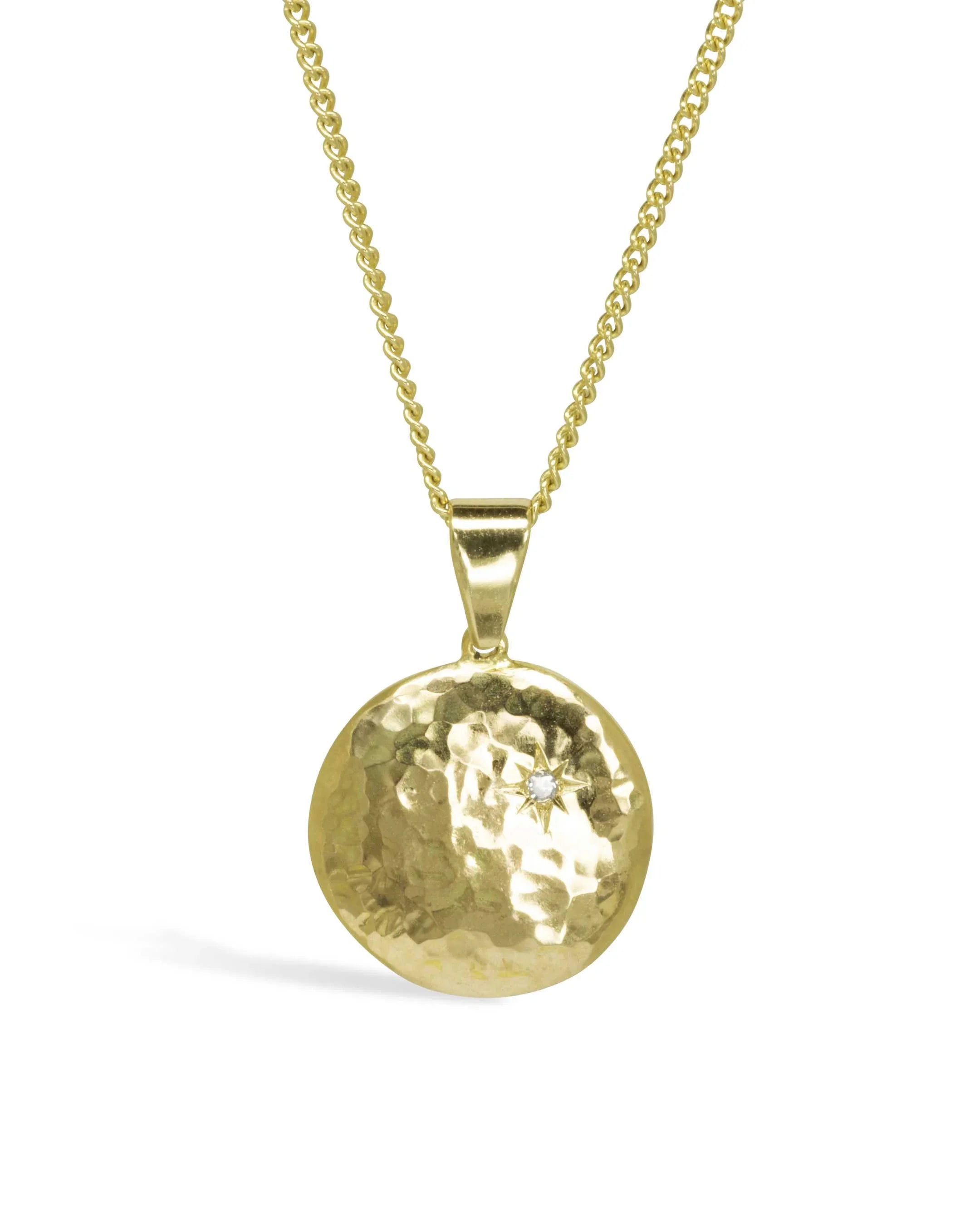 Hammered gold disc pendant necklace with diamond star engraving on a gold chain