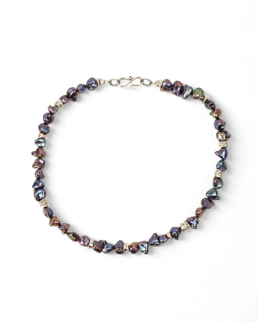 Handmade black keshi pearl necklace with organic shapes and silver clasp on white background