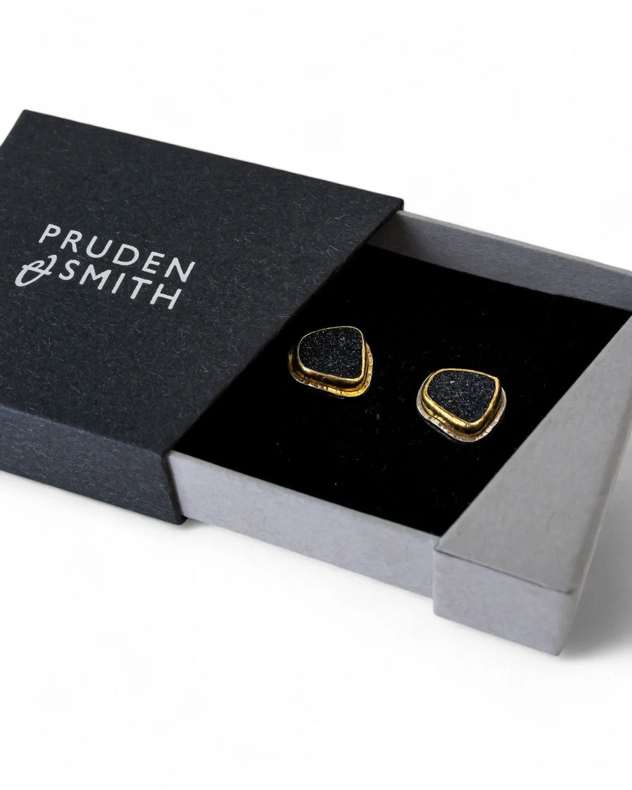 Black onyx druzy stud earrings with gold-toned edges in a black gift box.