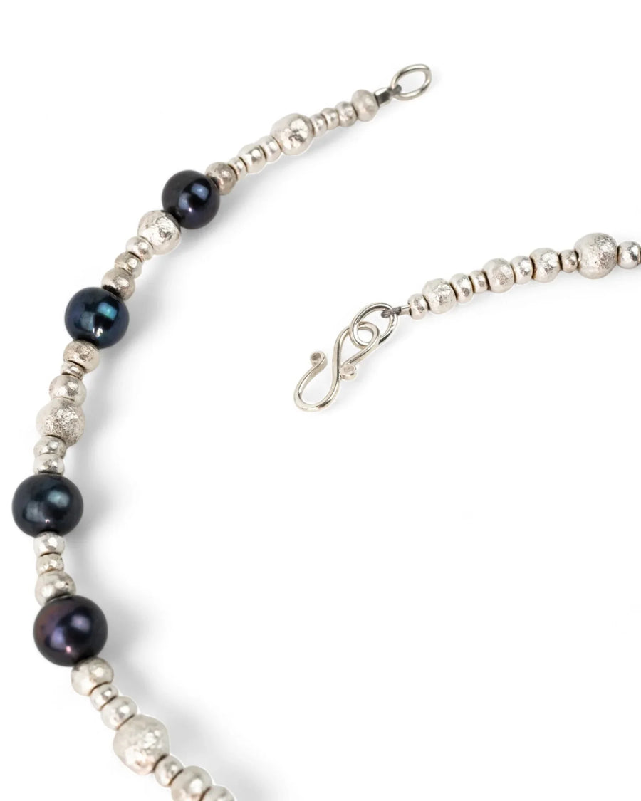 Black pearl and silver nugget beaded necklace with handmade clasp on white background