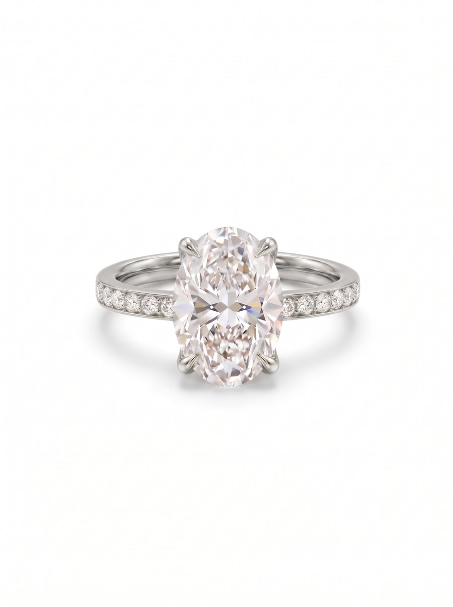 Oval lab diamond solitaire engagement ring with a pavé band set in polished white metal.