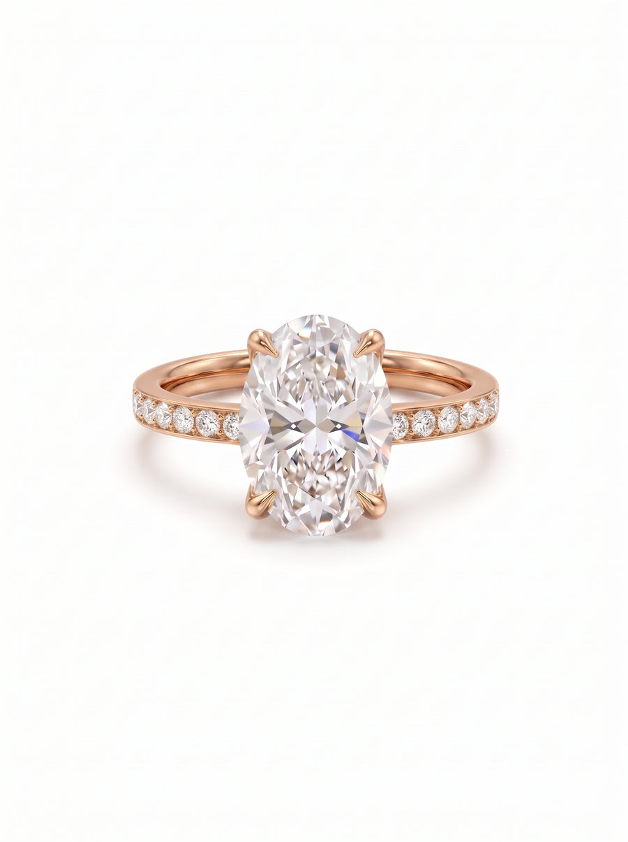 Oval diamond solitaire engagement ring set in a rose gold band with pavé diamonds.
