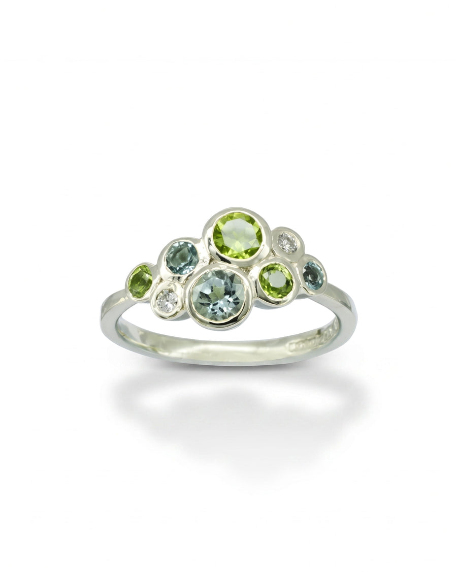 Silver ring with aquamarine, peridot, and diamond cluster design.