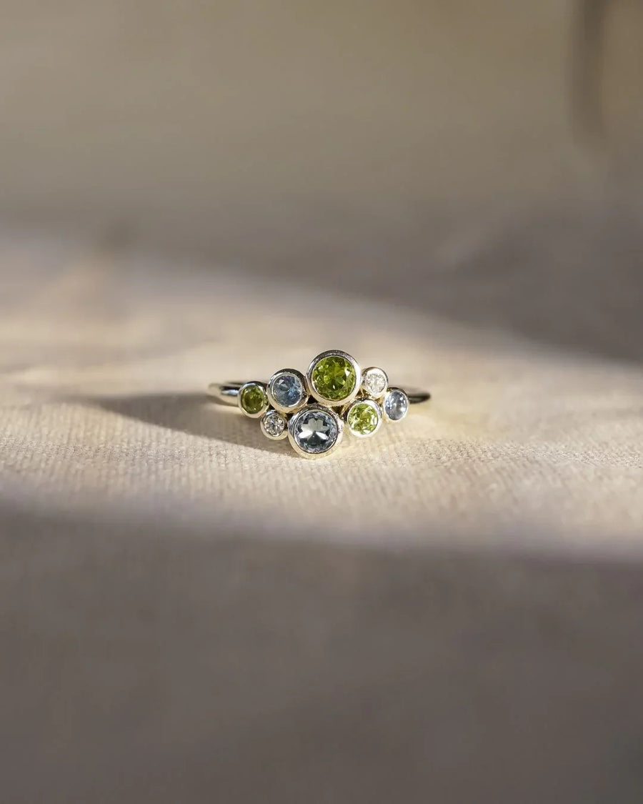 Silver cluster ring with aquamarine, peridot, and diamond gemstones.