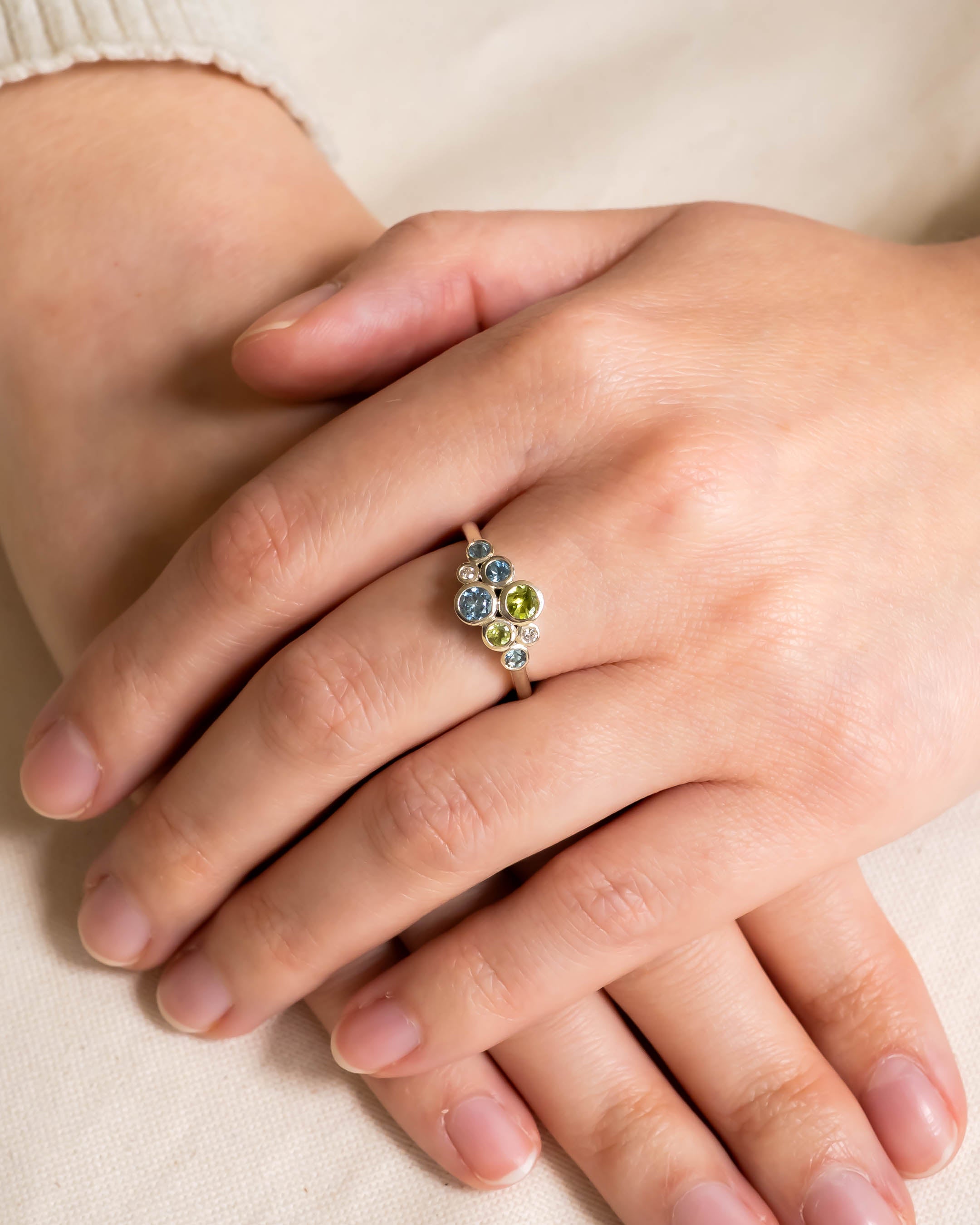 Silver cluster ring with aquamarine, peridot, and diamond gemstones.